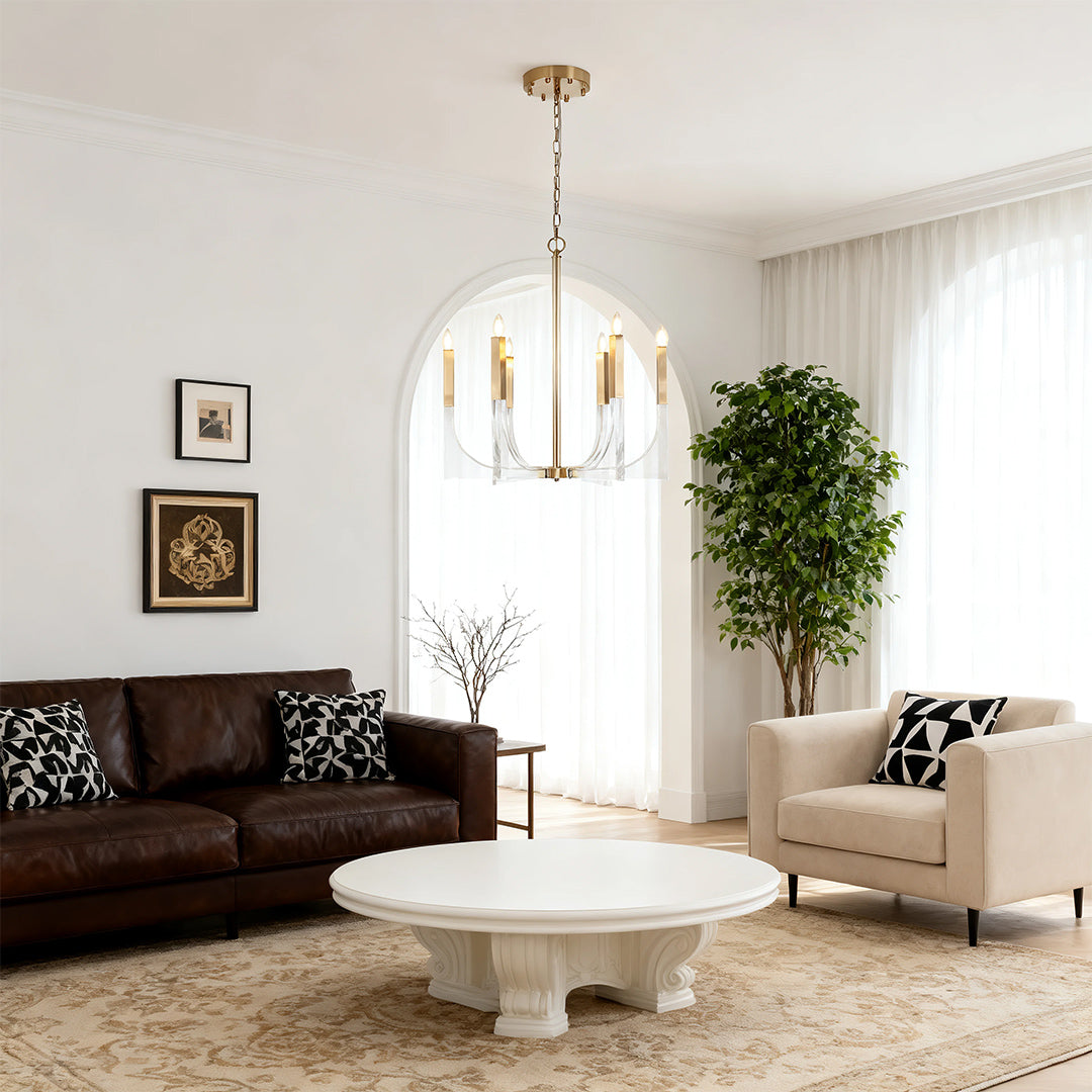 Acrylic chandeliers featuring six candle-style lights, suspended over a dark leather sofa in a bright, arched-window living space.