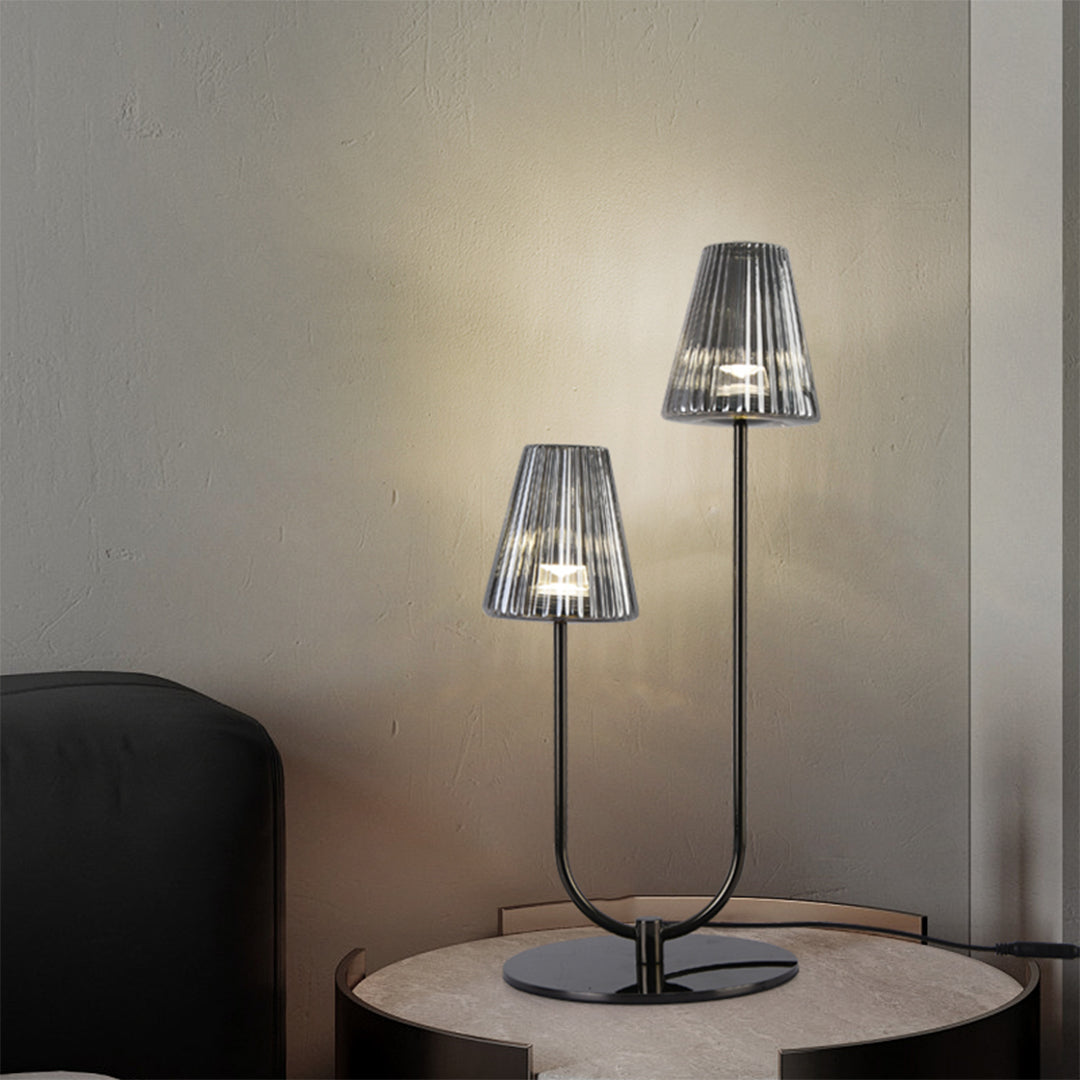 Sleek black elegant table lamps with a U-shaped base on a modern grey round side table setup.