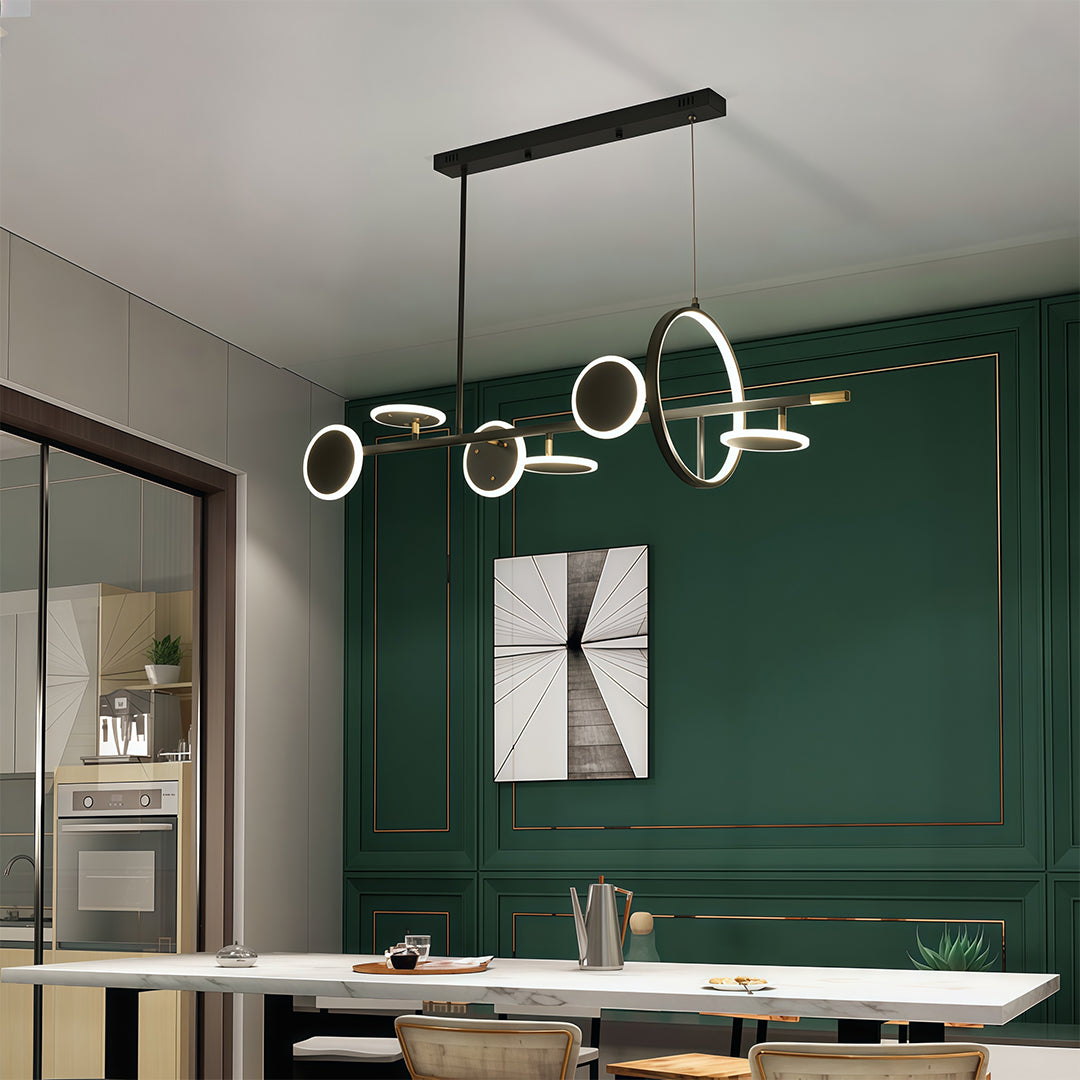 Sleek 6 light chandelier with black and gold accents, illuminating a dining area with a deep green accent wall.