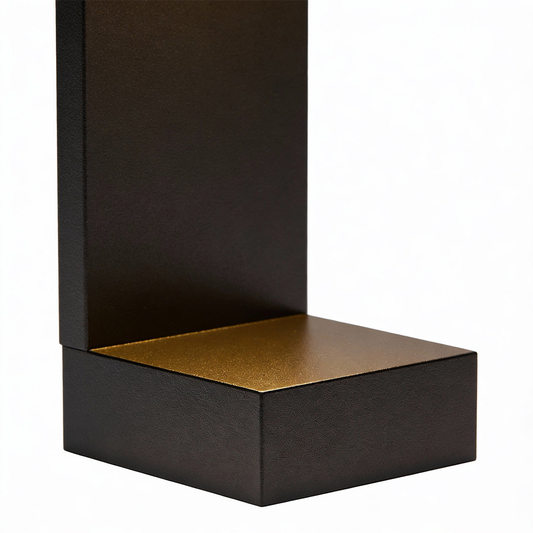 Modern landscape pathway lights featuring sleek black rectangular design with warm golden top, ideal for contemporary garden walkways.