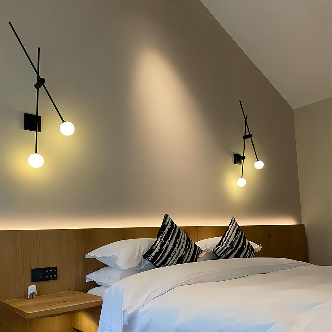Sleek black linear wall light with adjustable arms and spherical bulbs in a modern interior