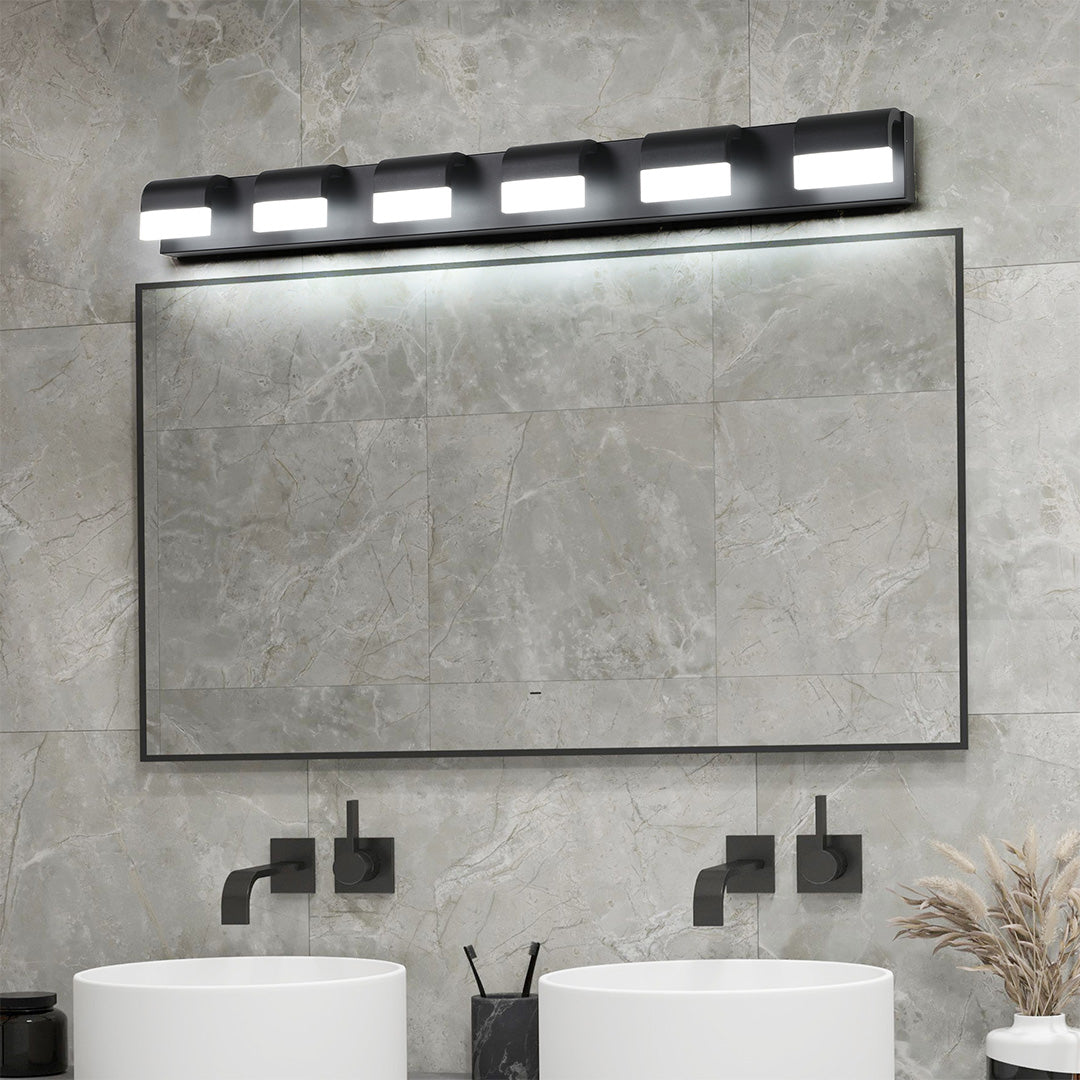 Sleek black vanity lighting for bathroom featuring glass shade chandelier influenced six-light bar above concrete vanity wall.