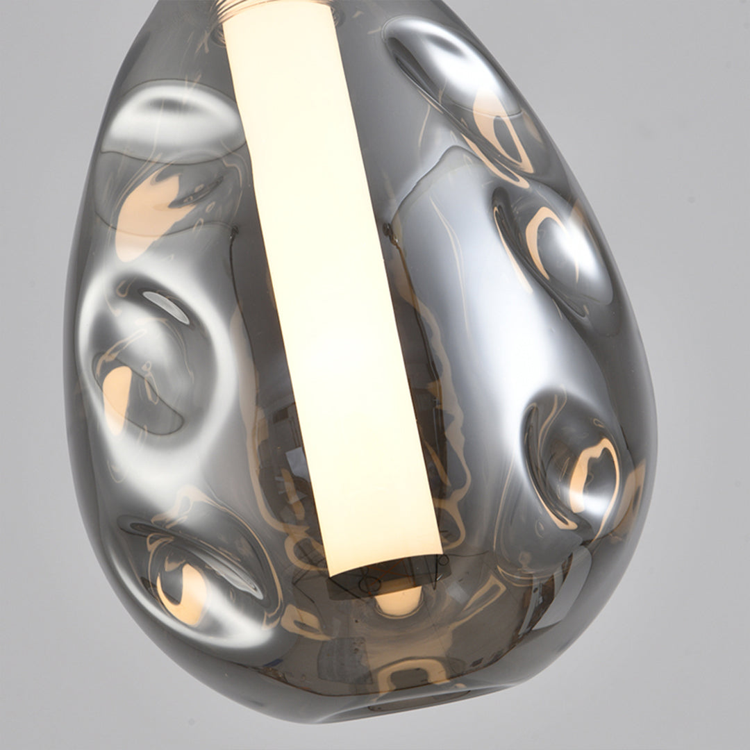 Sleek drum pendant lights with reflective chrome surface and geometric opening pattern