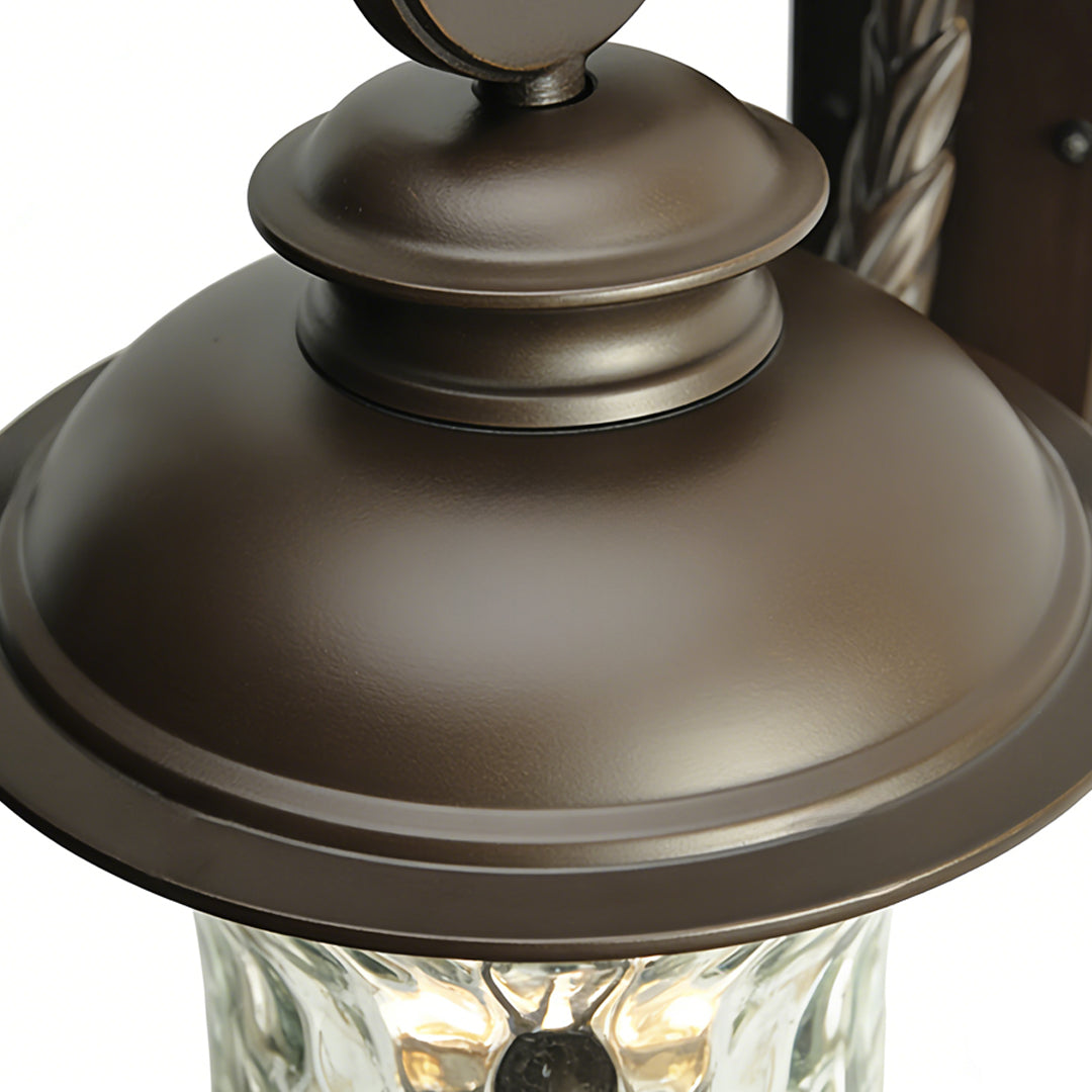 Sleek black exterior wall light with smooth dome top and bronze finish, perfect for modern outdoor lighting solutions.