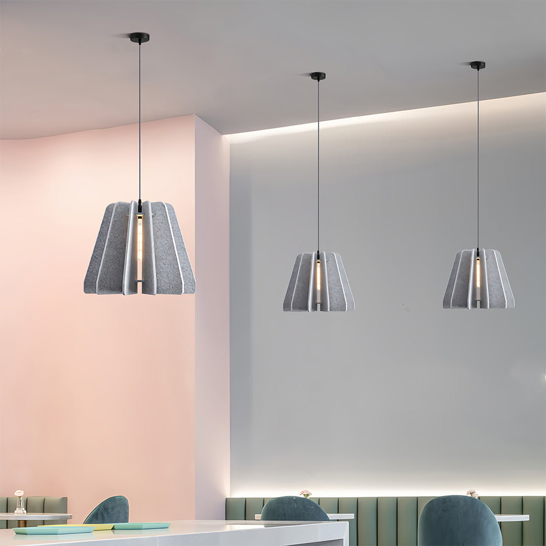 Sleek grey metallic 1 light single pendant lighting used to provide focused illumination in a minimalist commercial space.