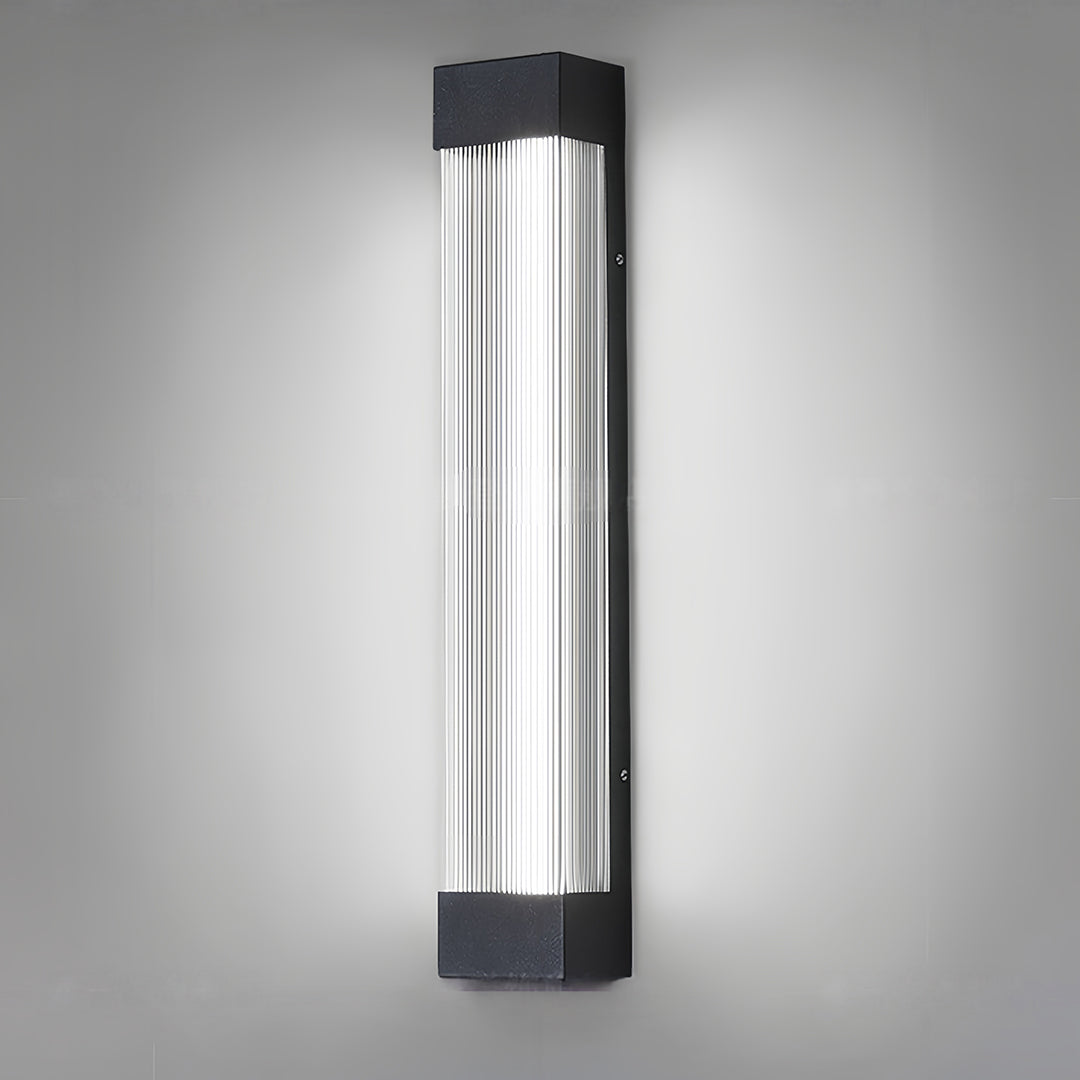 Sleek linear outdoor sconce shown emitting a cool white light, isolated against a simple background.
