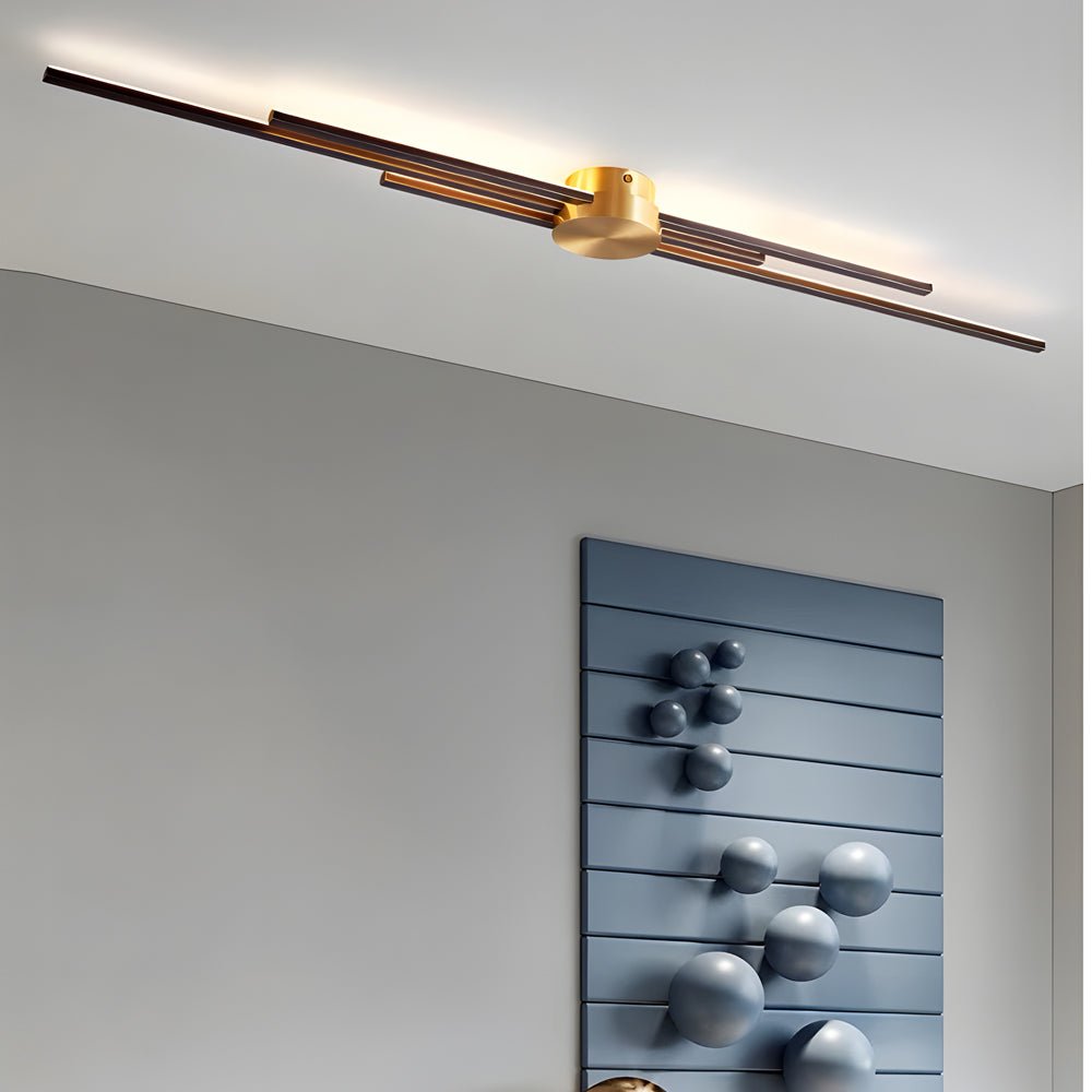 Sleek and modern linear wall sconce with gold and black finish, ideal for brightening up a modern bedroom or living area.