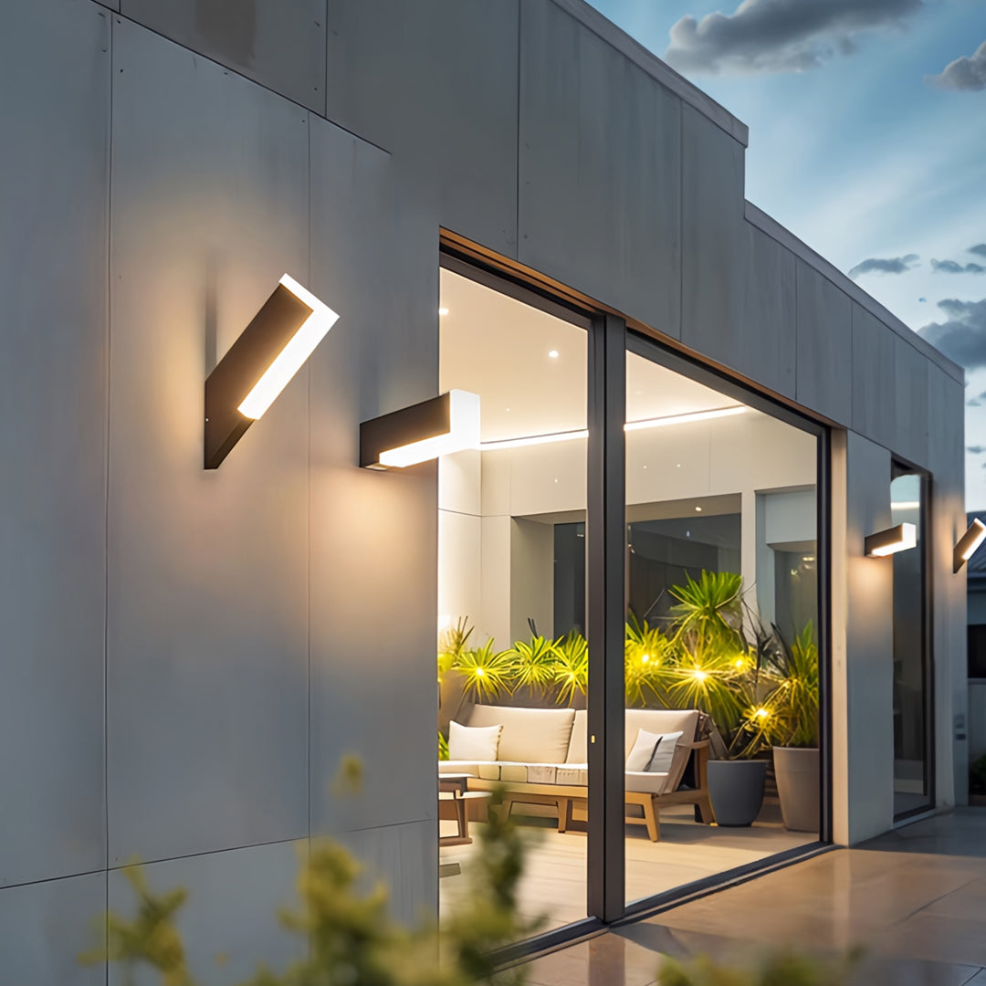 Sleek outdoor wall lantern light fixtures installed along contemporary exterior walls providing warm lighting.