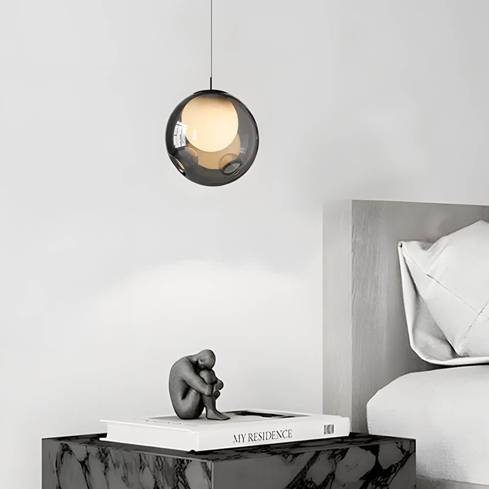 Sleek single smoked glass pendant light bedside lamp in a minimalist modern bedroom decor setup