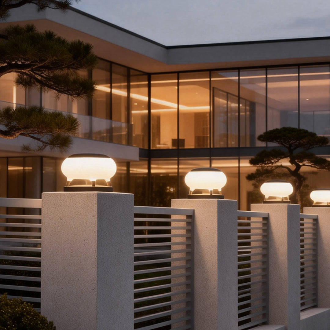 Sleek solar column pillar lights mounted on stone pillars, providing ambient lighting for a modern house entrance.