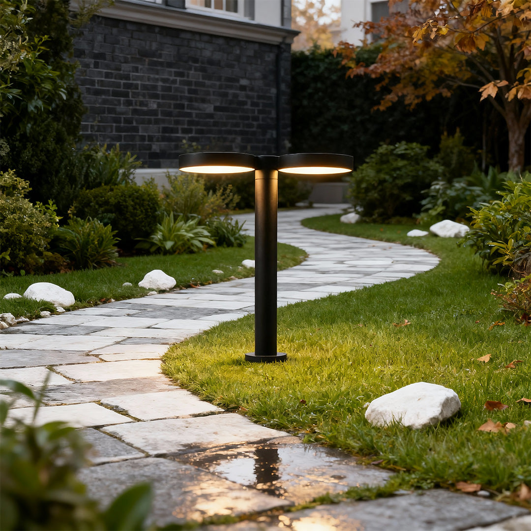 Sleek solar path light with a soft glow, placed along a stone pathway in an outdoor space.