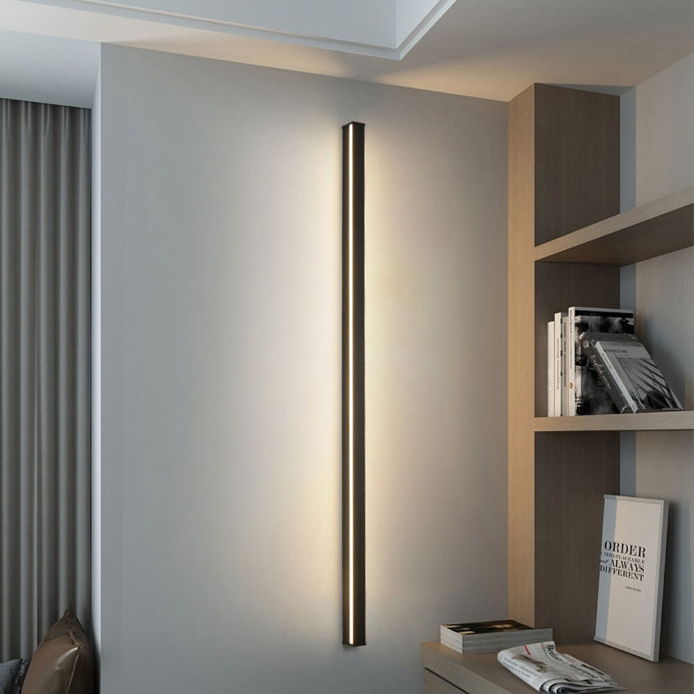 Sleek vertical linear outdoor wall sconce with warm light, installed on brick wall for modern exterior lighting.
