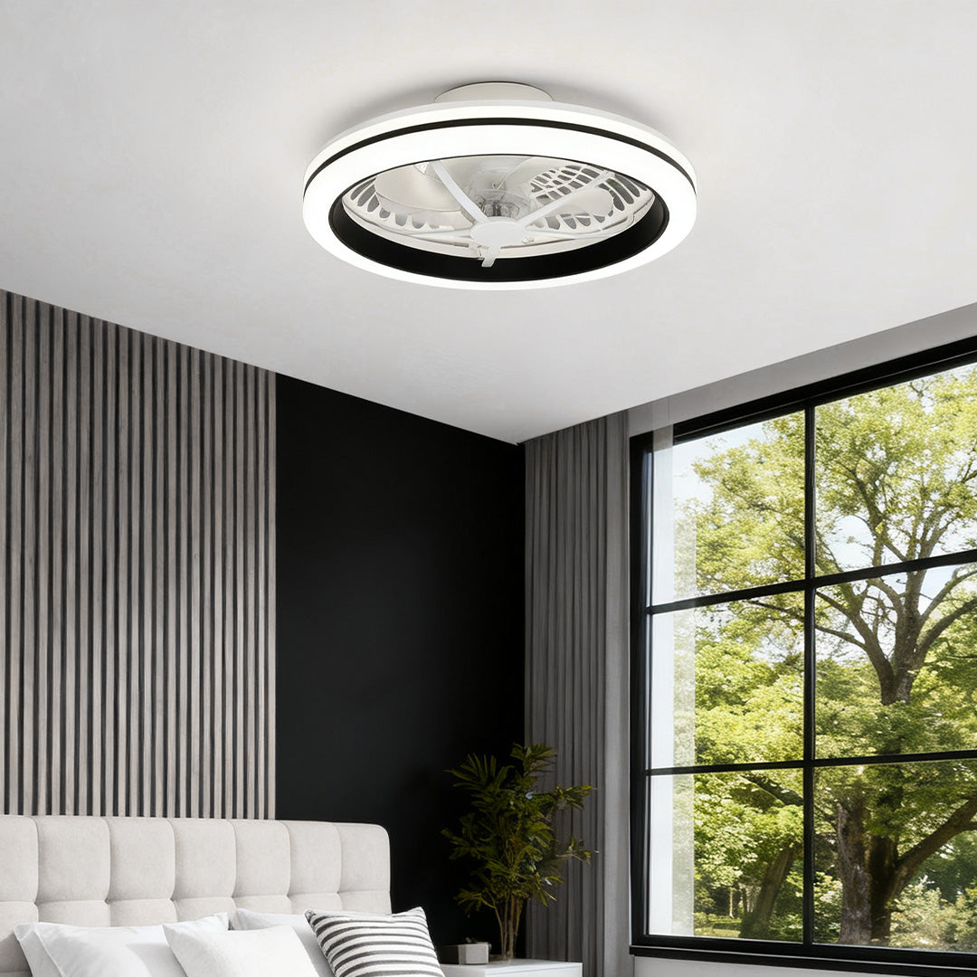 Sleek white flush mount ceiling fan with light above a bed in a bright room with a large window and contemporary vertical paneling. 