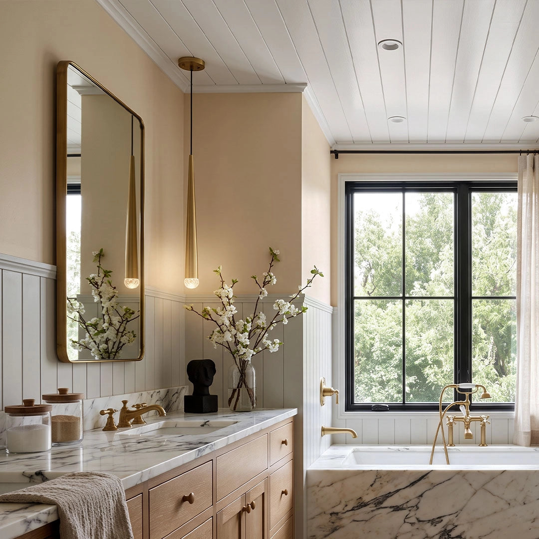 Slim gold cone pendant lights hanging beside a bathroom mirror above a double vanity.