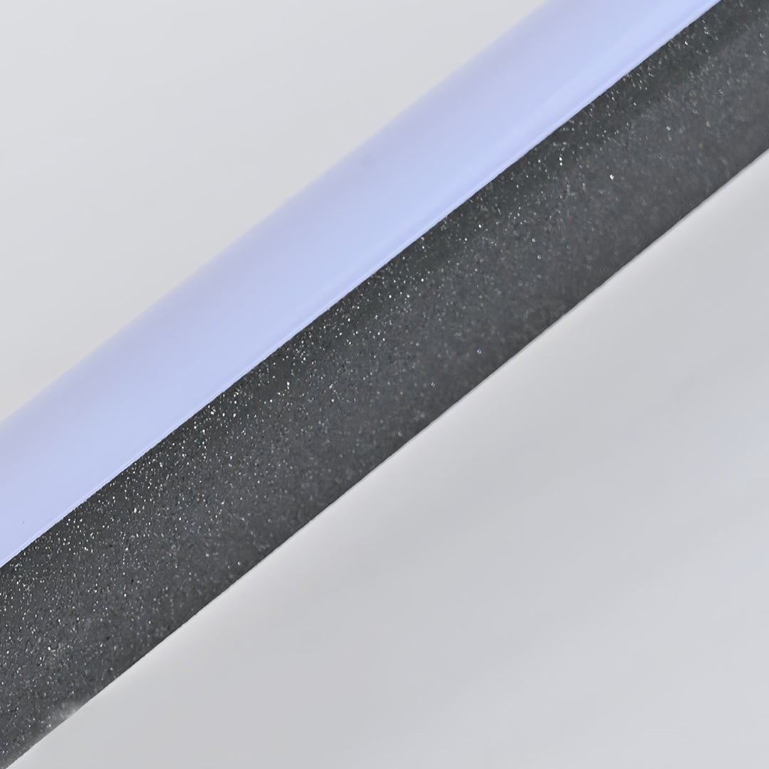 Close up of slim linear LED light surface with dark metal housing.