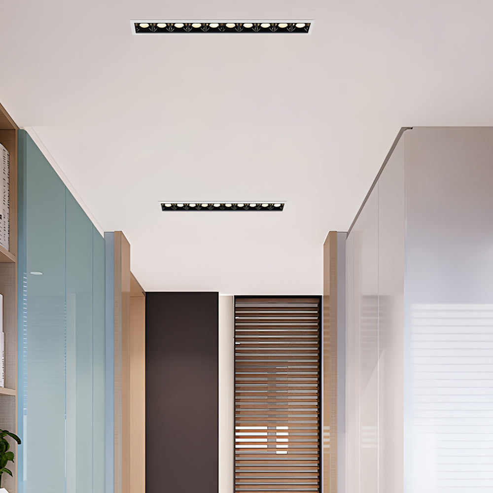 Slim recessed ceiling spot lights installed in a bright modern hallway.