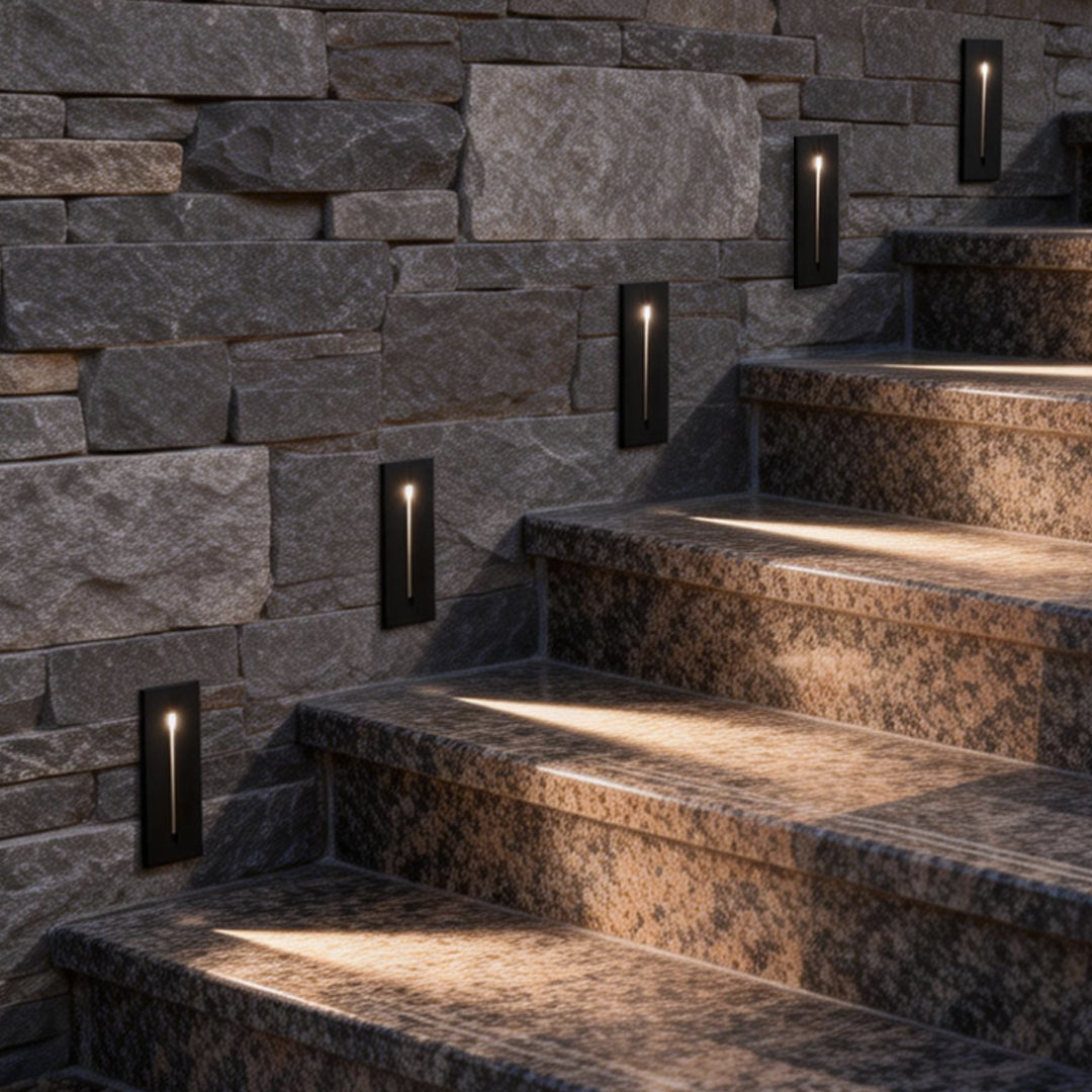Slit stair lamp illuminating a modern stone staircase with warm directional glow.