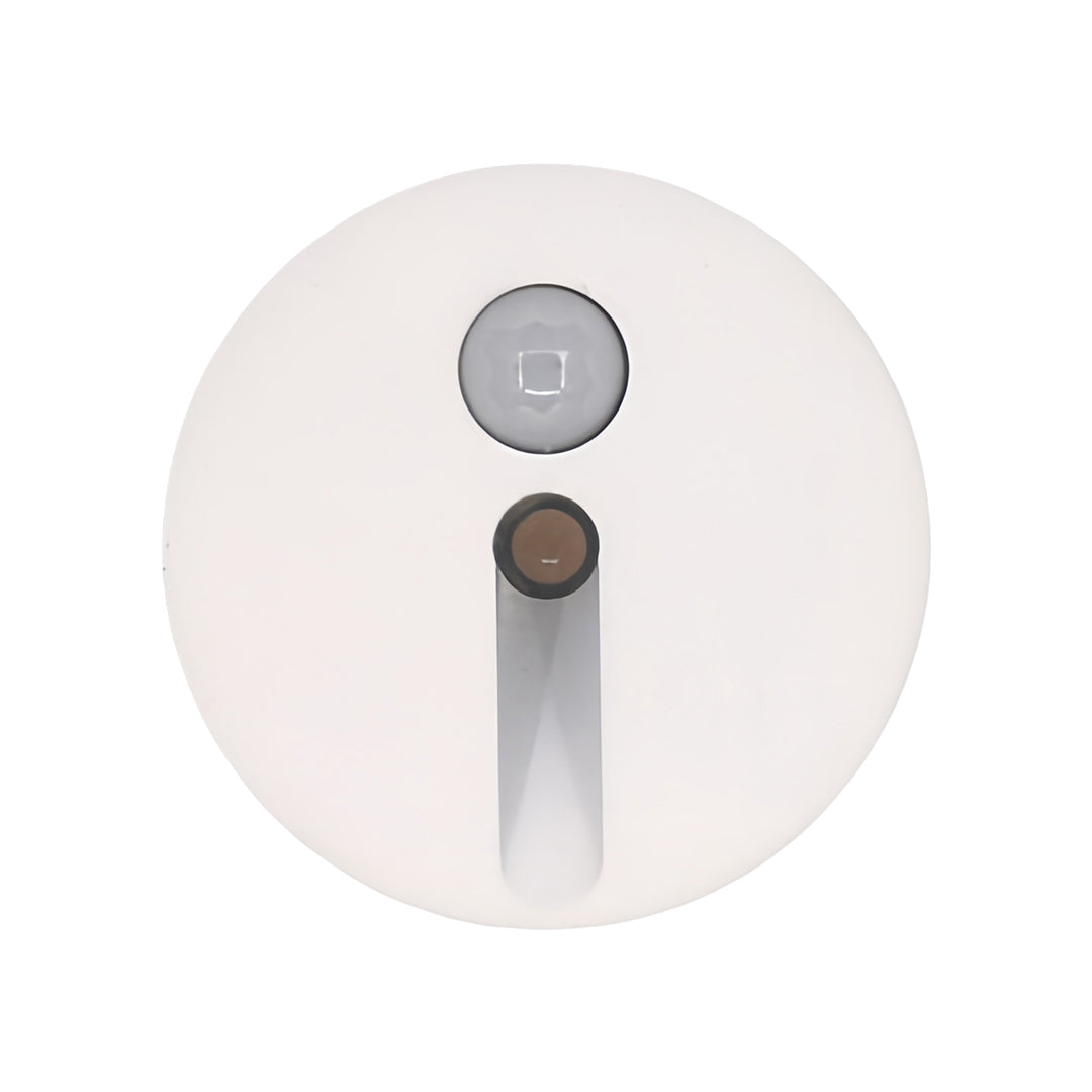 Small circular interior stair step lights in white, showcasing the discreet design with a vertical light slot, perfect for seamless integration into baseboards or wall risers.