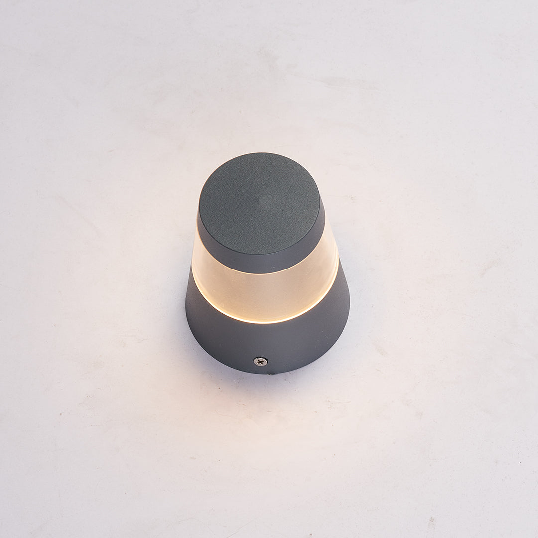 Small landscape lights illuminated on a plain background, showing warm light diffusion through the fixture.