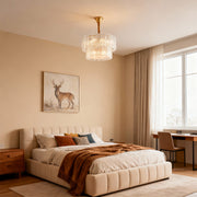 Modern luxury chandeliers creating warm glow in elegant bedroom with tufted headboard and rust tones