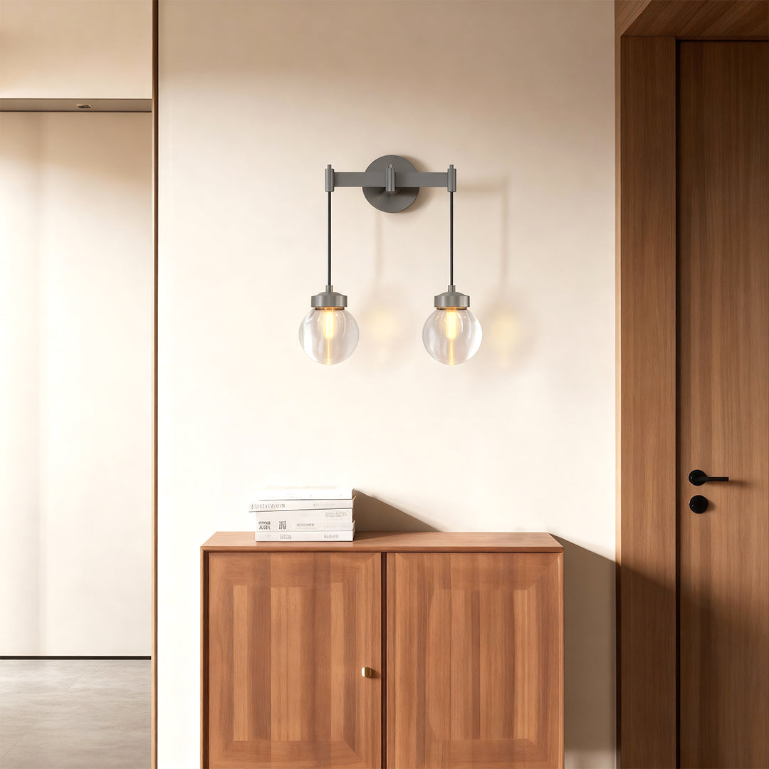 Small modern chandeliers providing ambient lighting above wooden console in hallway