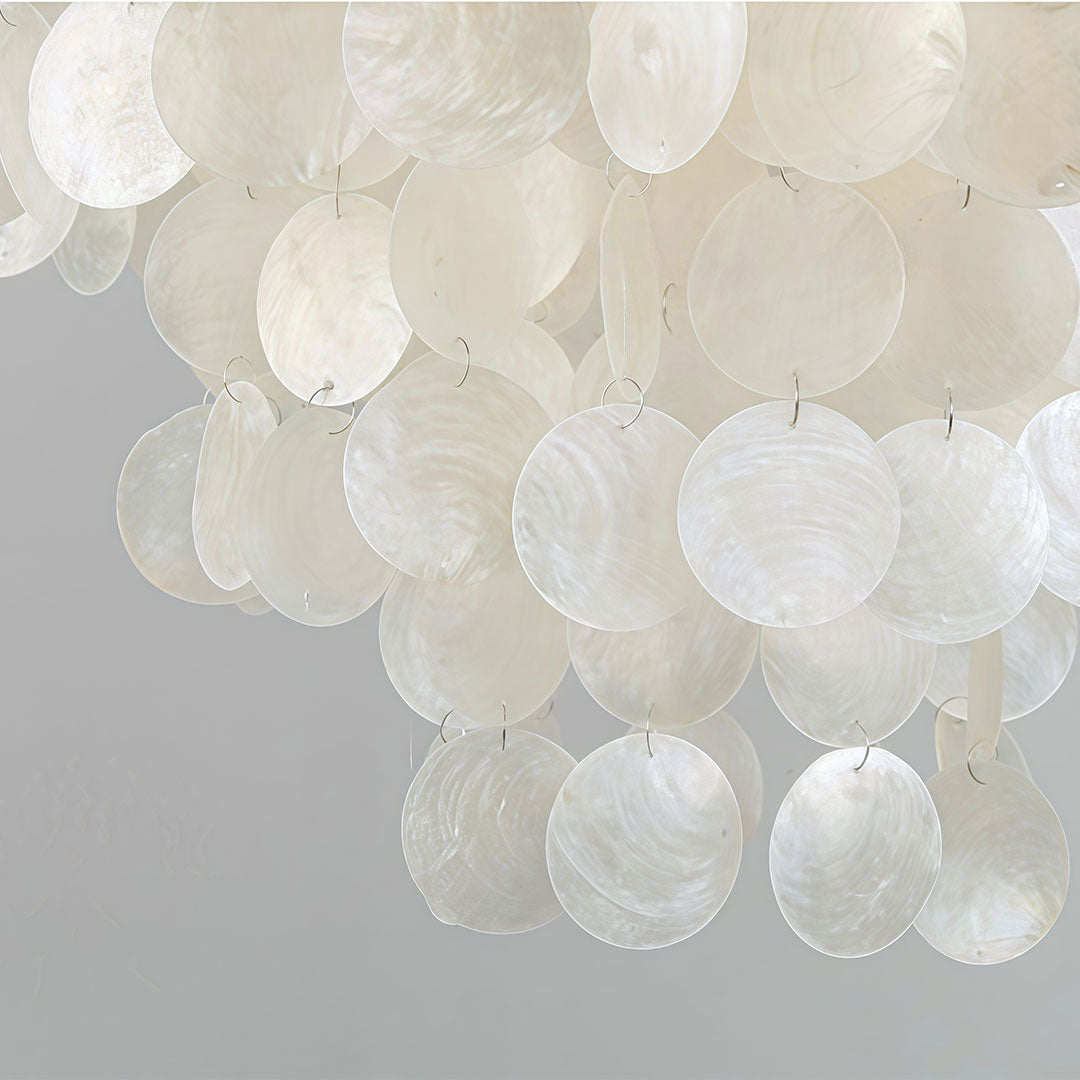 Small staircase chandelier close-up showing translucent shell-like glass disc details.