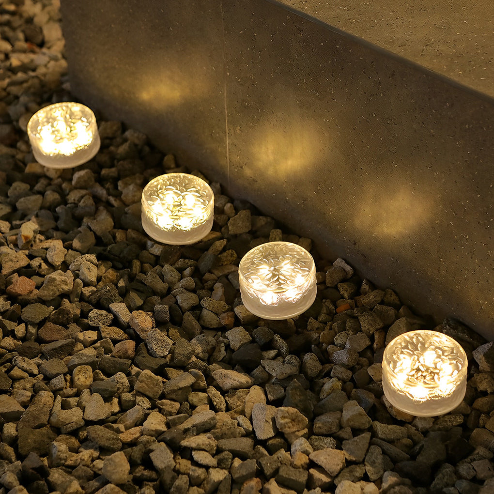 Small step lights set in gravel beside outdoor steps creating ambient ground lighting.