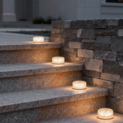 Small step lights placed on outdoor stone stairs providing subtle pathway illumination at night.