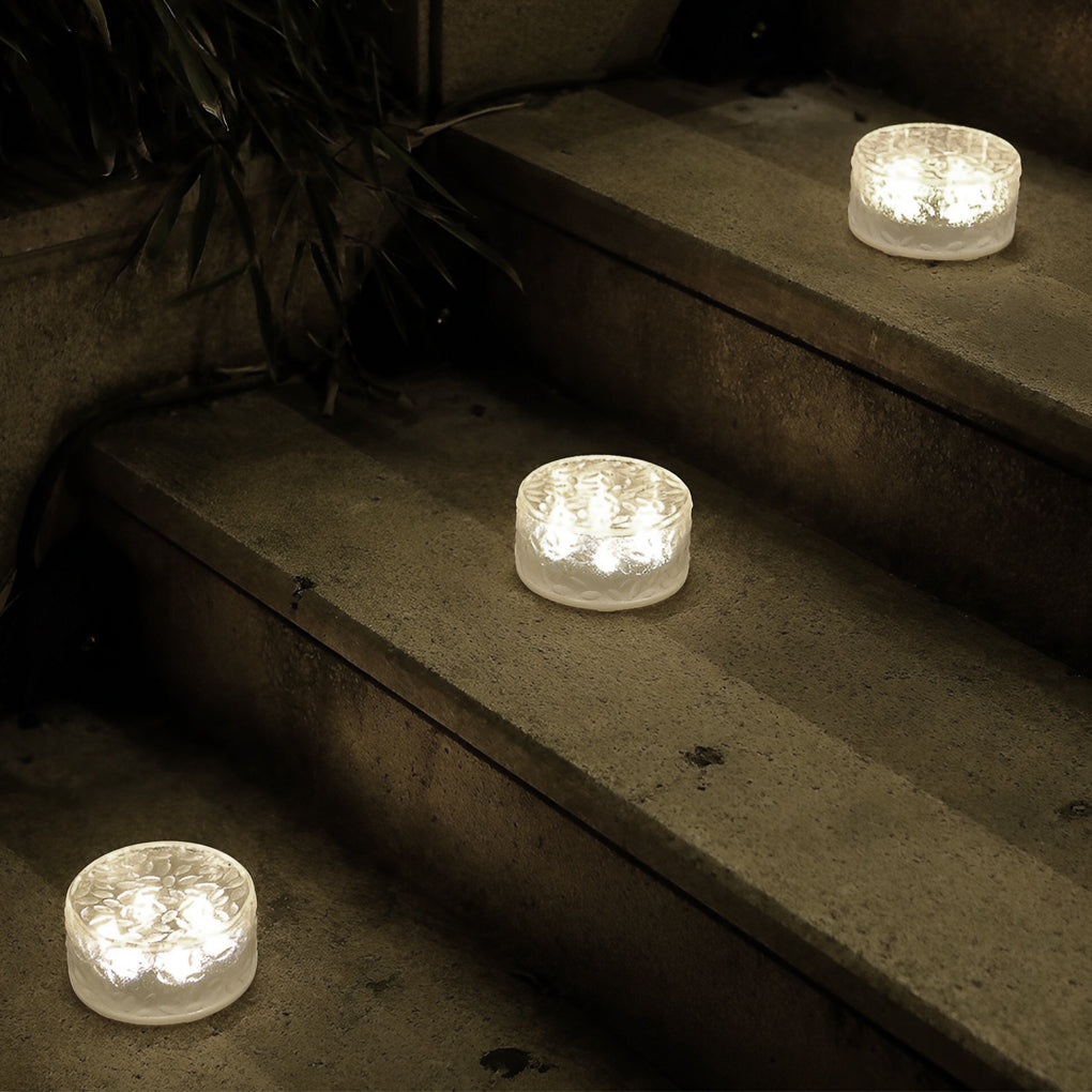 Small step lights positioned on stair treads offering decorative and safety lighting at night.