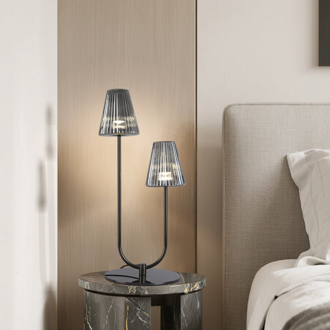 Elegant table lamps with smoke grey ribbed glass shades on a marble bedside table in a bedroom.