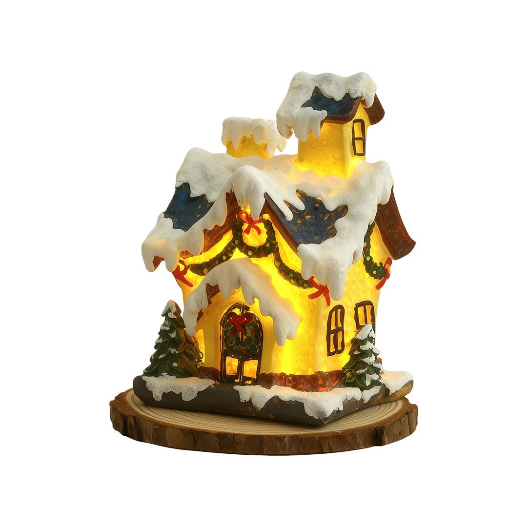 Glowing snow-covered Christmas house figurine with warm LED lights and festive detailing.