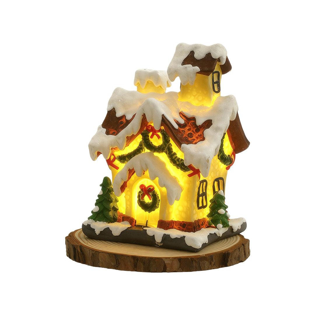 Glowing snow-covered Christmas house figurine with warm LED lights and festive detailing.