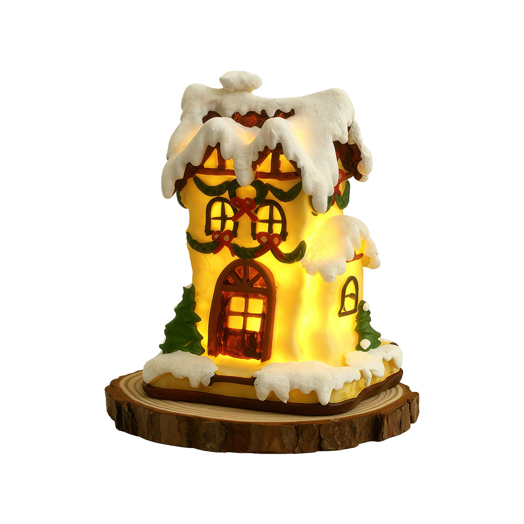 Glowing snow-covered Christmas house figurine with warm LED lights and festive detailing.