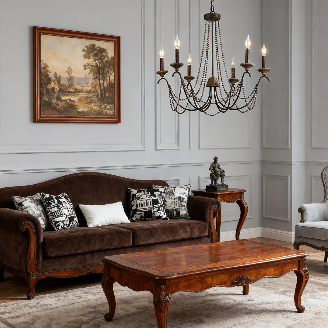 French style chandelier providing soft ambient light in a living room, complementing the velvet sofa and classic wall paneling.