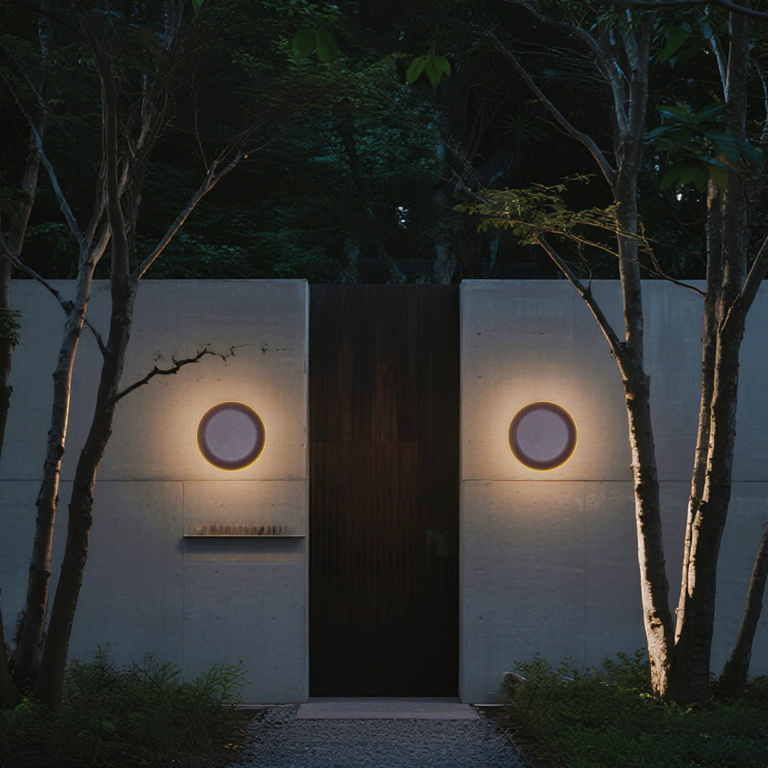 Soft-edge square waterproof outdoor wall light with diffused golden illumination on neutral stone