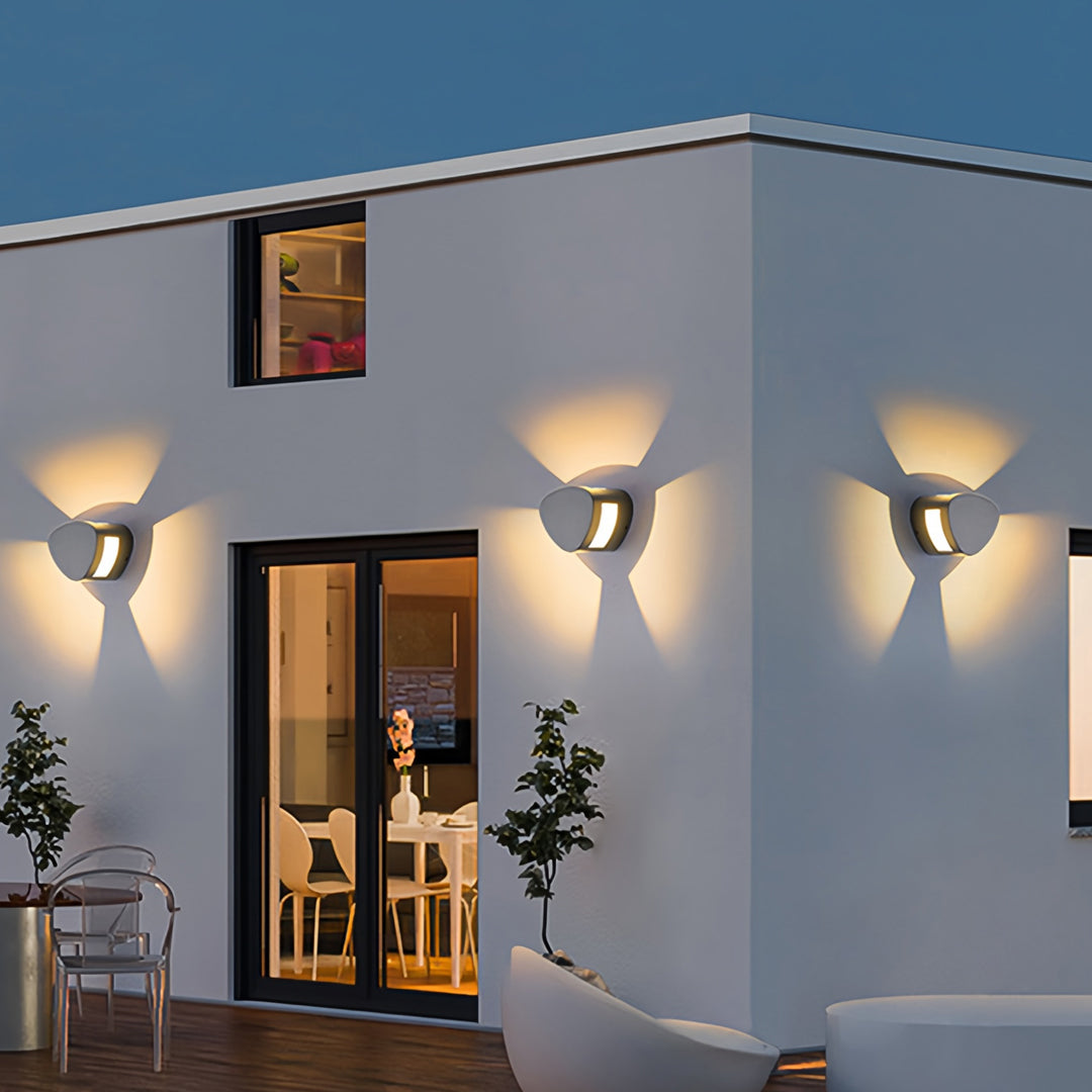 Soft glowing wall light outdoor fixtures installed along a clean white exterior wall.