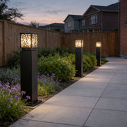Solar bollard path lights illuminating a modern garden walkway with warm ambient glow.