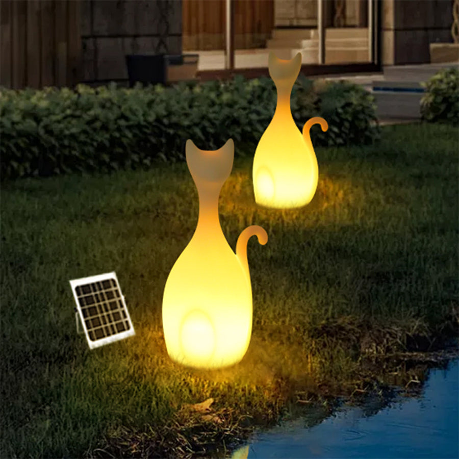 Solar-powered cat light with attached solar panel positioned on grass for garden decoration