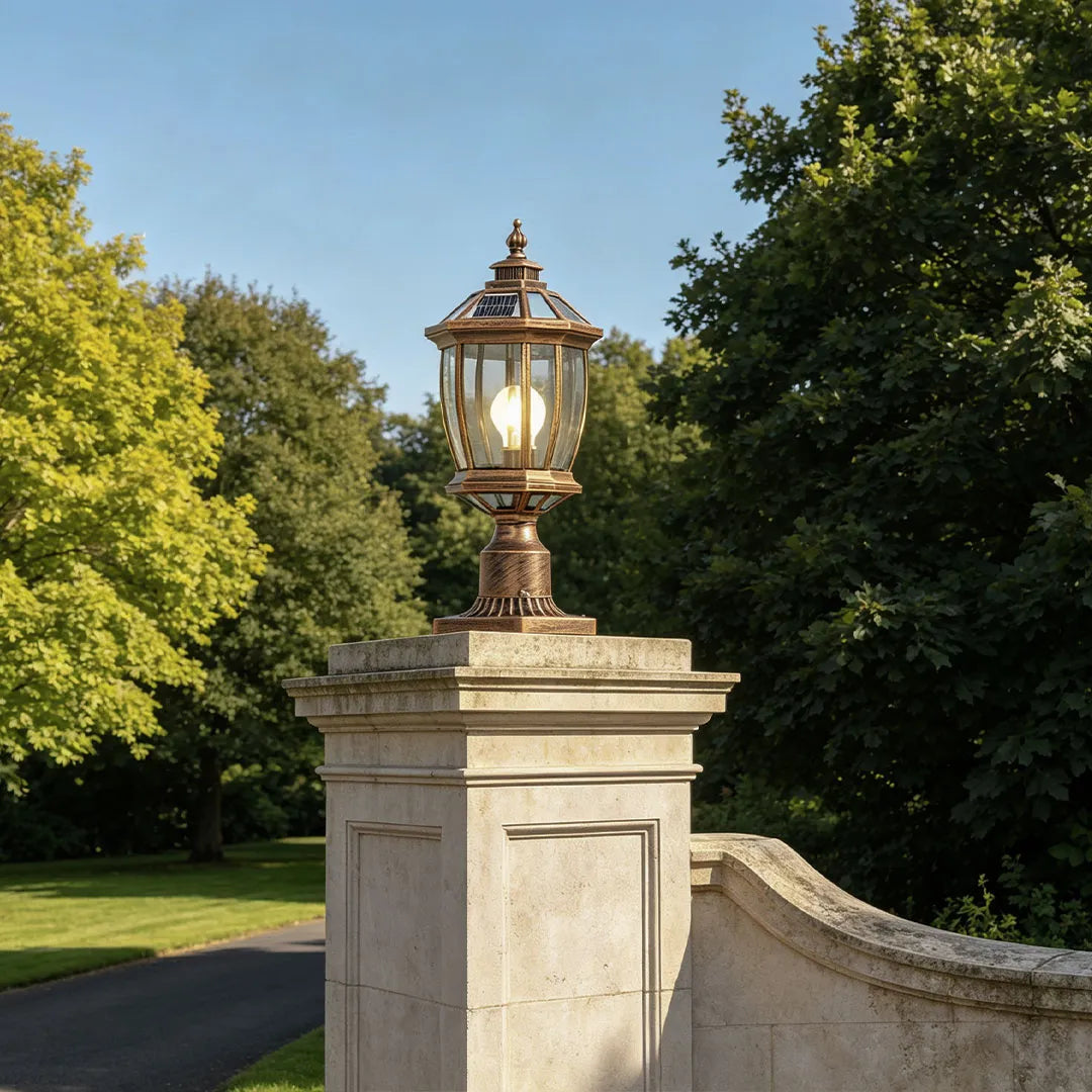 Solar column pillar light displayed on a tall stone gate post in a landscaped yard.