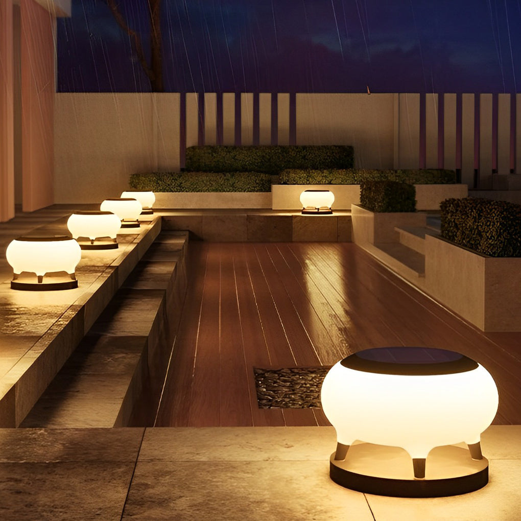 Solar column pillar lights providing focused illumination for a landscaped garden and stone pathway.