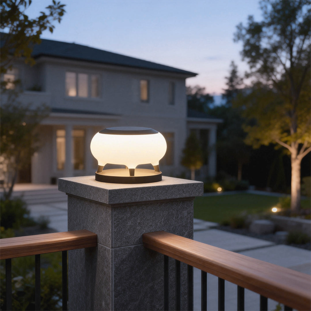 Solar column pillar lights with modern white design illuminating a residential driveway and garden at dusk.