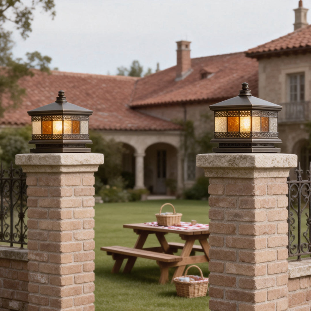 Classic solar column pillar lights mounted on stone pillars near a courtyard, providing soft illumination for outdoor dining areas.