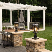 Solar column pillar lights installed on stone patio columns beside a white pergola.