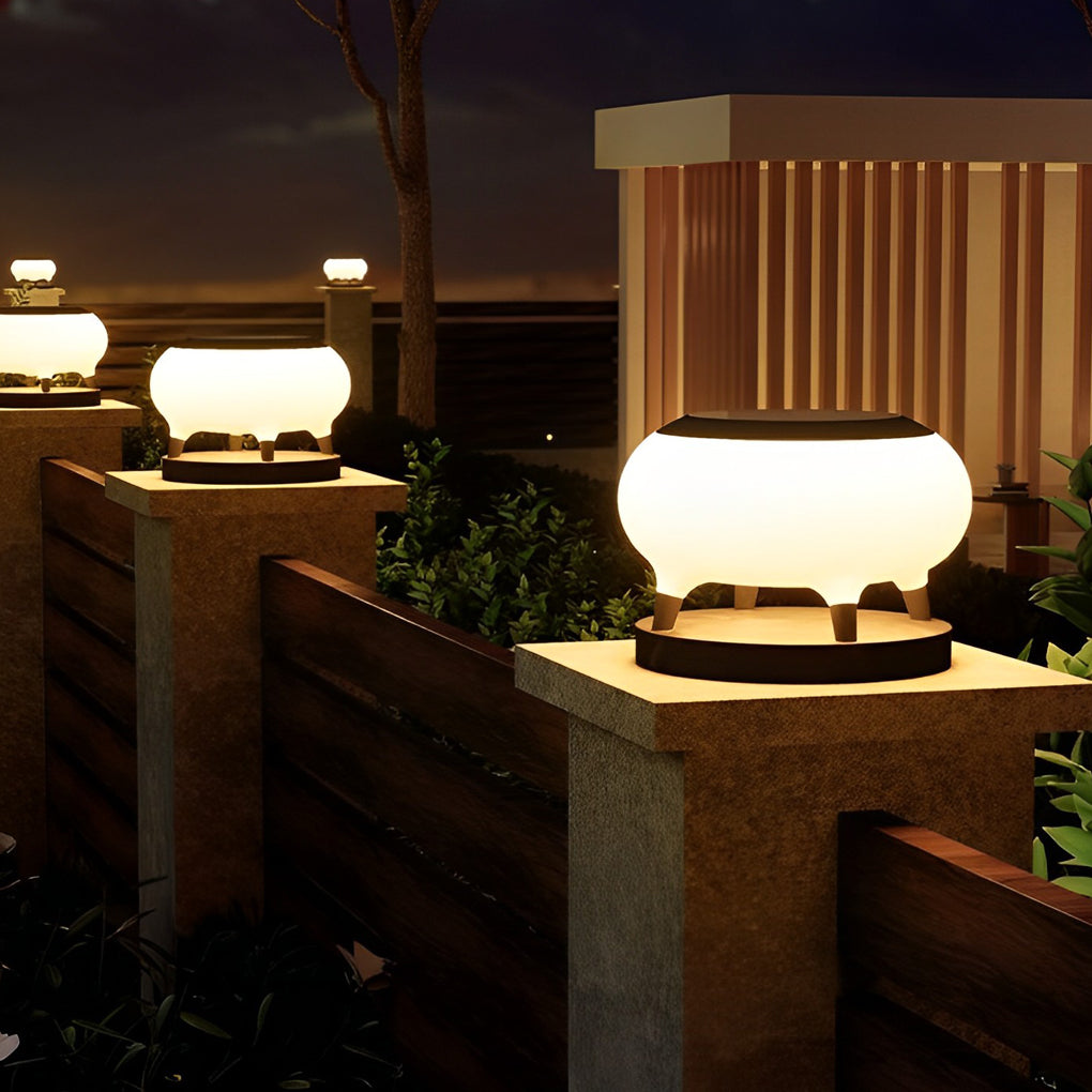 Solar column pillar lights with warm glow enhancing the pathway and fence area of a contemporary home.