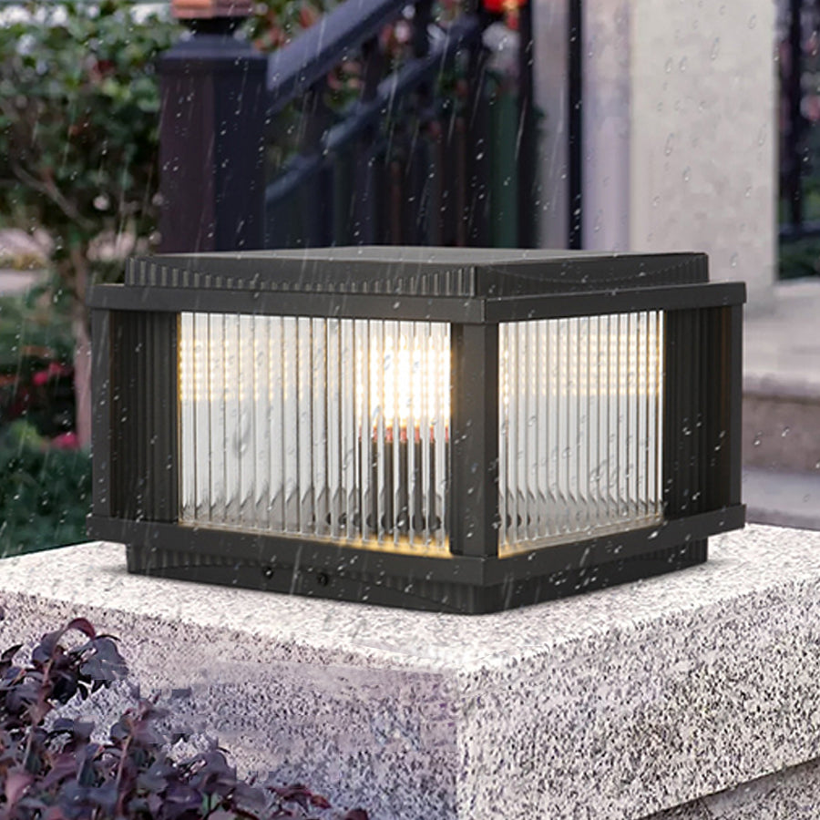 Solar outdoor pillar light with ribbed glass design installed on concrete surface for pathway illumination