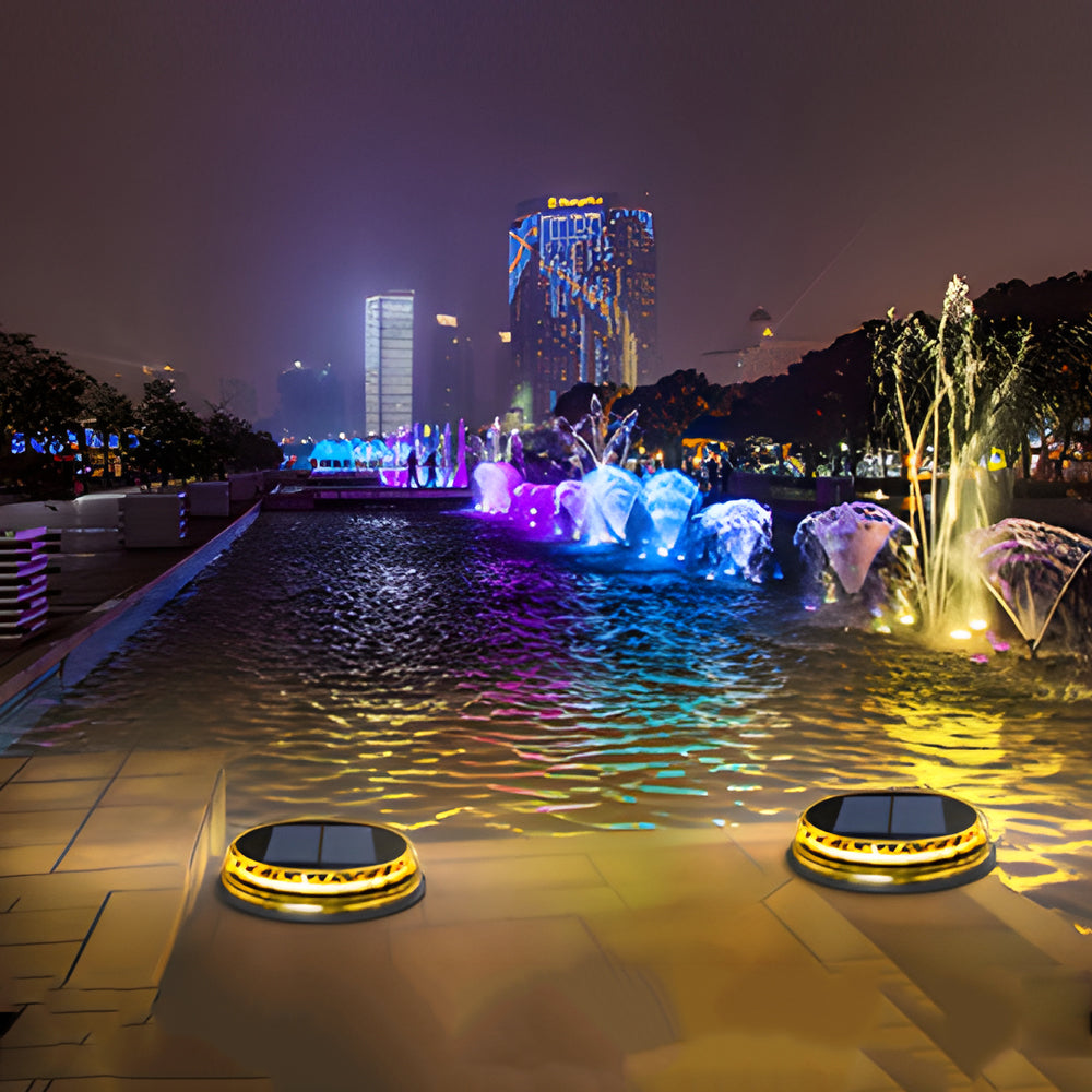 Solar disc light lining a waterfront walkway, creating a magical nighttime atmosphere.