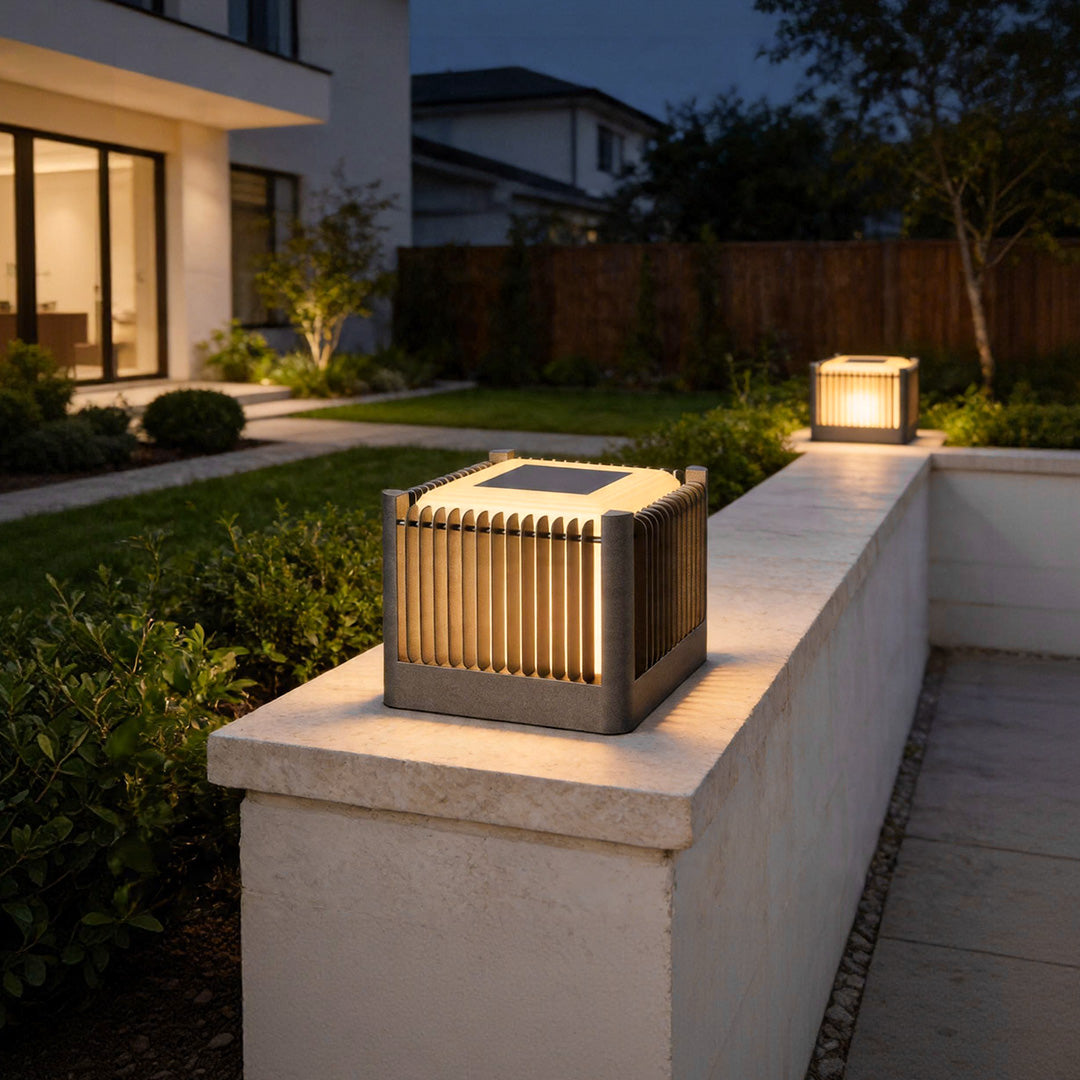 Solar driveway pillar lights illuminating modern outdoor pathway wall with warm ambient lighting.