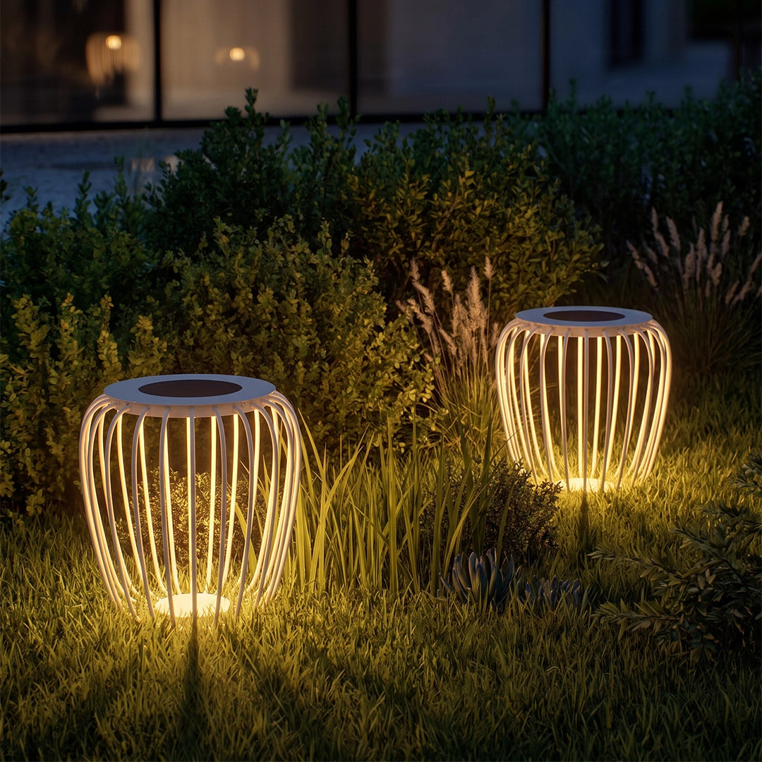 Solar garden lanterns illuminating tall grass and shrubs with a warm glow at dusk.