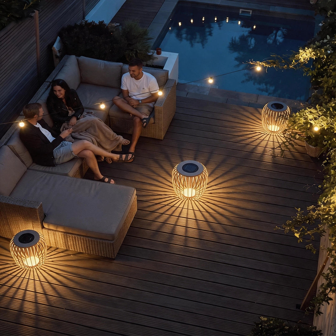 Solar garden lanterns lighting a poolside deck and outdoor lounge area at night.