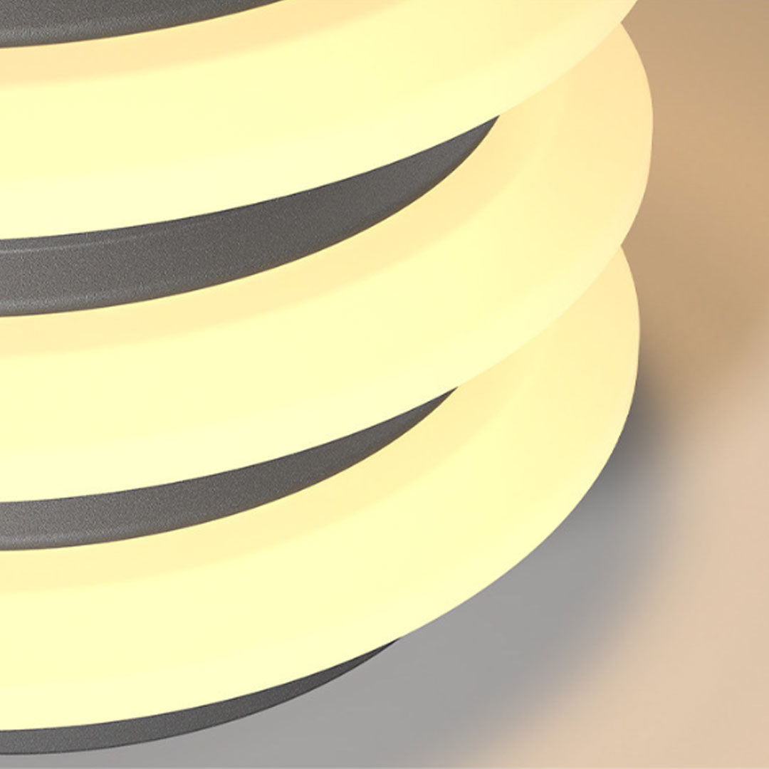 Detailed view of solar garden pillar lights with glowing circular layers and textured metal finish.